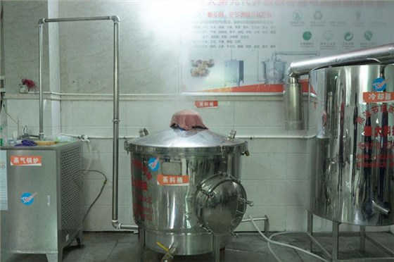 將發酵好的醪糟倒入雅大白酒釀酒設備中蒸餾
